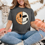 Halloween Face DTF Heat Transfer, a woman wearing a dark gray T-shirt with a skull graphic divided into a leopard print and a plain design, in a festive Halloween decorated room.