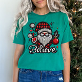 Believe Faux Embroidery DTF Heat Transfer, festive Christmas-themed design of Santa Claus with ornaments on a turquoise t-shirt.