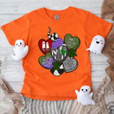 Beetle Hearts DTF Heat Transfer, colorful tattoo-style design featuring various hearts with text and a small green lizard, printed on orange T-shirt with plush ghost toys around it.