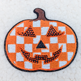 Checkered Jack O Lantern Rhinestone Embroidered HAT/POCKET Patch, Halloween pumpkin face embroidered patch with checkered pattern, rhinestone embellishments, and detailed stitching.