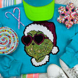 Heart Eyes Green Guy Sequin Patch, a colorful embroidered patch featuring a green face with heart-shaped sunglasses wearing a Santa hat, decorated with shiny sequins.