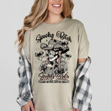 Spooky Bitch Social Club DTF Heat Transfer, a graphic design featuring a skeleton styled as a woman with braided hair, wearing a cowboy hat, with bows, skulls, and the text 'Spooky Bitch Social Club' on a beige T-shirt.