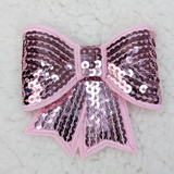 Light Pink Sequin Bow Hat/Pocket Patch, decorative pink fabric bow with shiny pink and purple sequins and embroidery, suitable for clothing or accessories.
