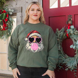 Santa Blowing Bubblegum DTF Heat Transfer, humorous holiday graphic featuring Santa with heart-shaped sunglasses and blowing pink bubblegum, on a woman's green sweatshirt for Christmas festivities.