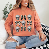 Skull Checker Bow DTF Heat Transfer, design of 3 skulls and 3 checkered bows on a woman's sweatshirt.