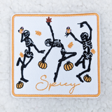 Spicy Dancing Skeletons Embroidered HAT/POCKET Patch, embroidered patch featuring dancing skeletons with pumpkins and the word "Spicy" on a white background.