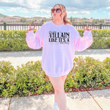 You Say Villain Like It's A Bad Thing DTF Heat Transfer, a woman outdoors wearing a white sweatshirt with the phrase 'you say VILLAIN LIKE IT'S A bad thing' printed on it.