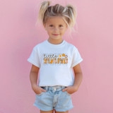 Little Wildflower DTF Heat Transfer, on a young girl wearing a white t-shirt with floral text design