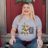 Life Is Better In The Woods DTF Heat Transfer, cheerful woman wearing a gray T-shirt with a moose and pine tree graphic and the text 'Life is Better in the Woods' outdoors.