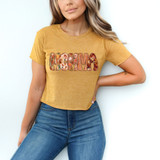 Momma Fall Pattern DTF Heat Transfer, a floral patterned decal with fall motifs on a yellow T-shirt worn by a woman.