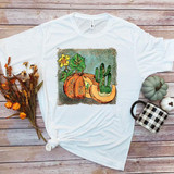 Watercolor Leopard Pumpkin Sublimation Transfer, illustration of a pumpkin with leopard print, surrounded by cacti and greenery, on a white T-shirt.
