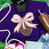 Sequin Football with Pink Sequin Bow Patch, a decorative athletic-inspired patch featuring a football with pink sequined bow accents, on a purple sweatshirt.