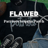 FLAWED Patriots Sequin Patch, image showing a black sweatshirt with the word 'Patriots' in sequins, surrounded by football-themed accessories and white bead necklaces.
