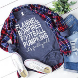 Flannels Bonfires Footballs Pumpkins Screen Print Transfer, a casual fall outfit with a graphic t-shirt, plaid shirt, ripped jeans, and sneakers with a green plant in the background.