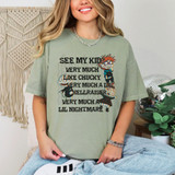 See My Kid Very Much Like Chucky Very Much A Lil Hellraiser Very Much A Lil Nightmare *Glitch Effect* DTF Heat Transfer, a woman wearing a light green T-shirt with the text 'See My Kid Very Much Like Chucky Very Much A Lil Hellraiser Very Much A Lil Nightmare' and graphic illustrations with a glitch effect.