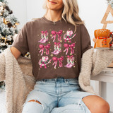 Pink Bow Cowgirl Boots DTF Heat Transfer, image of a woman wearing a T-shirt with pink cowgirl boots and bows design, holiday Christmas decor in the background.
