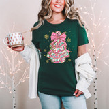 Preppy Snack Cake DTF Heat Transfer, festive Christmas-themed design on a dark green T-shirt featuring a decorated snack cake with a pink bow, holiday snowflakes, and colorful patterns.