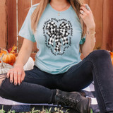 Thankful Blessed Grateful Black/White Plaid Bow DTF Heat Transfer, close-up of a woman wearing a light blue t-shirt with a black and white plaid bow design and circular text around it.
