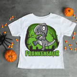 Frankenstein dinosaur Halloween dino Sublimation Transfer, cartoon dinosaur with Frankenstein-themed design on a white T-shirt surrounded by Halloween decorations and candies.
