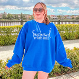 Transformed By God's Word WHITE DTF Heat Transfer, women wearing blue sweatshirt with white text, outdoor setting with lake and houses in background.