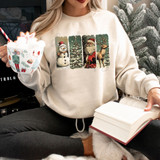 Vintage Distressed Christmas DTF Heat Transfer, Christmas-themed sweatshirt with snowman, Christmas tree, Santa Claus, and reindeer designs.