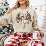 Ornament Bull Skull DTF Heat Transfer, front view of a festive sweatshirt featuring a bull skull ornament design with Christmas lights and ornaments, worn by a woman in a holiday setting.