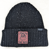 I Do It For The Ho's FAUX Leather Patch, black knitted beanie hat with speckled white details and a pink leather patch featuring a bearded Santa Claus wearing sunglasses.