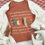 Thankful Multi Color DTF Heat Transfer, colorful thank you text design on a rust-colored T-shirt surrounded by white cardigan, dried pampas grass, and white shoes.