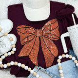 Sequins Basketball Bow Patch, sparkly orange sequin bow patch with black outline on a maroon sweatshirt.