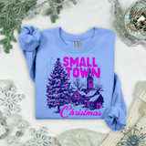 Small Town Christmas Navy/Pink DTF Heat Transfer, a colorful Christmas-themed heat transfer design on a light blue t-shirt featuring a Christmas tree, a church, and the text 'Small Town Christmas'.