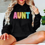 Bright Groovy Aunt Faux Sequins DTF Heat Transfer, colorful sequin embellished text on a black hoodie.