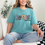 Be Still Psalm 46:10 DTF Heat Transfer, a colorful printed design on a teal T-shirt with the words 'Rejoice' and a Bible verse reference.