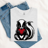 Love Skunk DTF Heat Transfer, adorable skunk holding a red heart, cute graphic design on a white T-shirt.