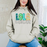 Lola She Is Clothed In Gratitude Counting Blessings Every Day DTF Heat Transfer, close-up of a woman wearing a beige hoodie with colorful, patterned word 'LOLA' and inspirational text about gratitude and blessings.