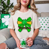 Momma St Patrick's Day Coquette Bow DTF Heat Transfer, woman wearing a T-shirt with a colorful shamrock bow design and the word 'Momma' on it, celebrating St. Patrick's Day.