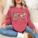 The Greatest Of These Is Love Patchwork DTF Heat Transfer on a pink sweatshirt, featuring colorful and patterned patchwork lettering of the word 'LOVE' with floral and geometric designs.