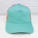 Aztec Patterned Trucker Style Hat, turquoise front panel with colorful patterned back and sides, curved brim, and adjustable snapback closure.