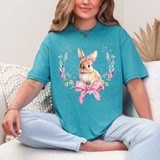 Easter Bunny Coquette DTF Heat Transfer, a colorful and cute bunny design with pink bow and floral wreath on a blue t-shirt.