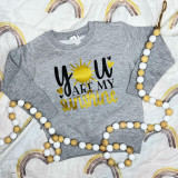 You Are My Sunshine INFANT- FINAL STOCK Screen Print Heat Transfer, gray infant sweatshirt with yellow and black sun and text design, decorative rainbow background, wooden bead necklace surrounding the sweatshirt.