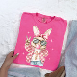 Retro Peace Bunny DTF Heat Transfer, pink T-shirt with a cartoon bunny wearing sunglasses, a pink bow, and a checkered jacket, peace sign, and fashionable accessories.