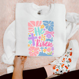 He Is Risen Minimalist DTF Heat Transfer, colorful Easter-themed design on a white sweatshirt.