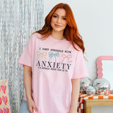 I Don't Struggle With Anxiety I'm Actually Pretty Good At It DTF Heat Transfer, a woman wearing a pink T-shirt with a humorous quote and bow illustrations.