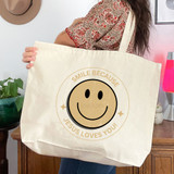 Smile Because Jesus Loves You Tan DTF Heat Transfer, tote bag with a smiley face and the text 'Smile Because Jesus Loves You' printed on it.