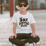 Camo Peace Out Fifth Grade DTF Heat Transfer, a child wearing a white t-shirt with this design, sitting outdoors with sunglasses, a cap, and casual attire.