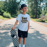 Camo Peace Out Seventh Grade DTF Heat Transfer, boy holding skateboard on a suburban street, wearing a white T-shirt with the design.