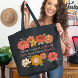 Mothers Plant Seeds Of Love That Bloom Forever Light Text DTF Heat Transfer tote bag with floral design, held by a smiling woman in a home setting.
