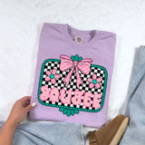 Boujee Turquoise DTF Heat Transfer, colorful design featuring a pink bow, flowers, and the word 'BOUJEE' on a purple t-shirt.