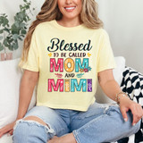 Blessed To Be Called Mom And Mimi DTF Heat Transfer, colorful floral and text design on a light yellow t-shirt worn by a smiling woman sitting on a sofa.