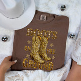 Boots On The Ground Faux Rhinestone DTF Heat Transfer, image of a brown T-shirt with a rhinestone graphic of cowboy boots and the text "Boots On The Ground".