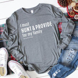 I Must Hunt and Provide For My Family FINAL STOCK Screen Print Transfer, gray sweatshirt with white text and hashtag #blackfriday, laid on a flat surface with jeans, sneakers, and holiday decorations around it.